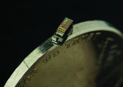 Фото самого маленького компьютера на фоне монеты